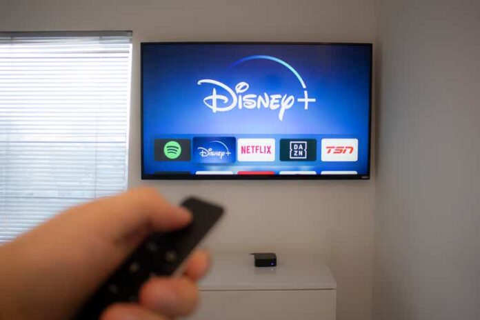 Person holds an Apple TV remote using the new Disney+ app on a Vizio TV. Disney+ video streaming service will exclusively show Star Wars: Jedi Template Challenge.