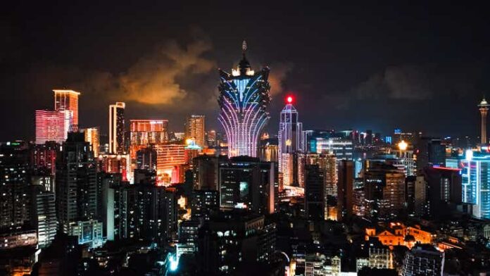 Cityscape view of Grand Lisboa Casino skyscraper building at Macau island, financial business or entertainment district. Drone aerial night view. Asia travel landmark concept