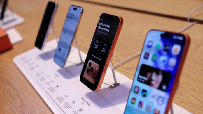 Four iPhone 17 models displayed upright on a store counter.