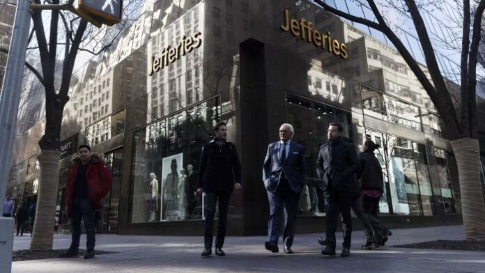 People walk past the Jefferies headquarters building in New York, with the company name visible on the facade.
