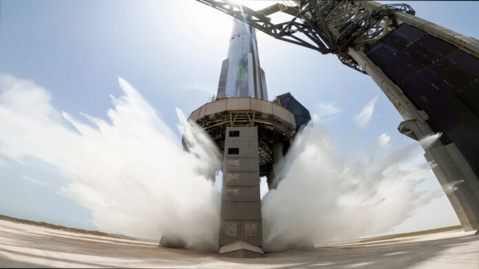 A view of SpaceX's starship system on the launchpad with the water-cooling flame deflector system active