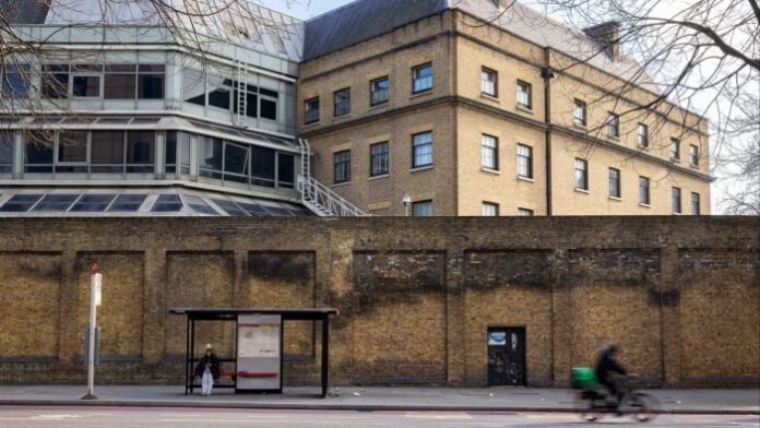 A section of the Royal Mint Court office complex is shown behind a brick wall