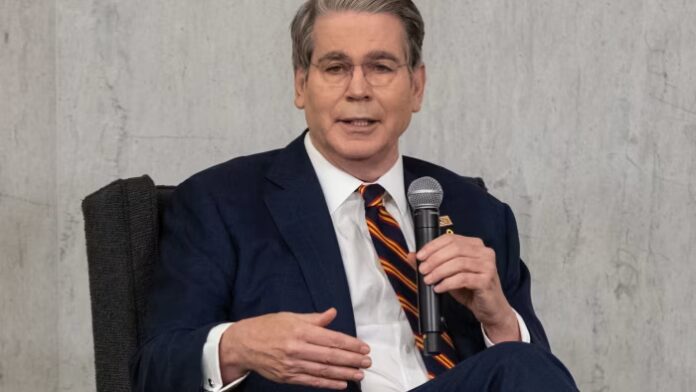 Scott Bessent speaks while holding a microphone during the Community Bank Conference.